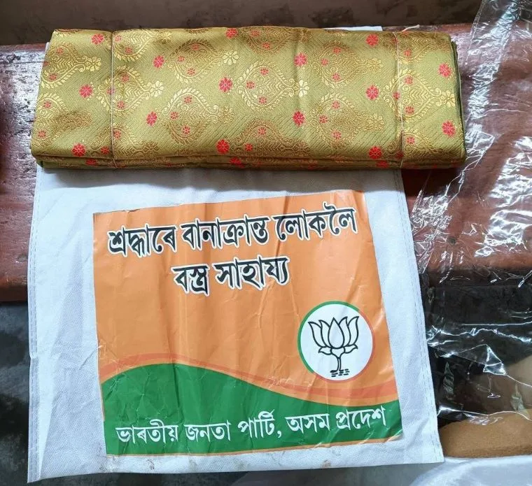 In the name of flood relief, the BJP is handing out polyester Mekhela Sadors ordered in bulk from factories in Surat, Gujarat